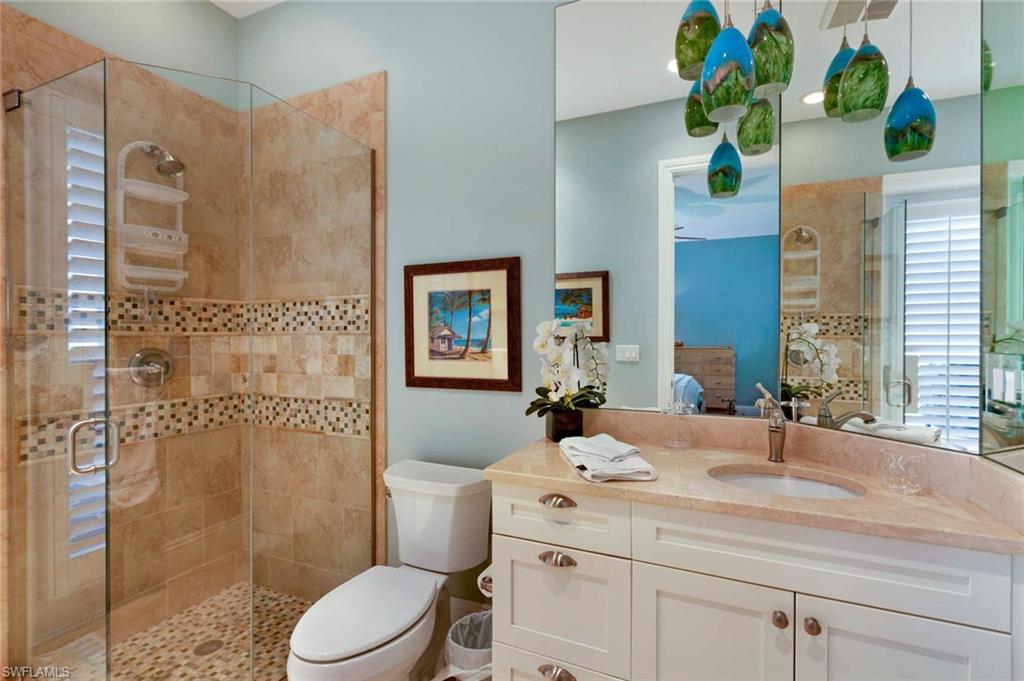 150 Central Avenue Naples, FL 34102 - Photo 17 of 35 a bathroom with a granite countertop sink a toilet a mirror and shower