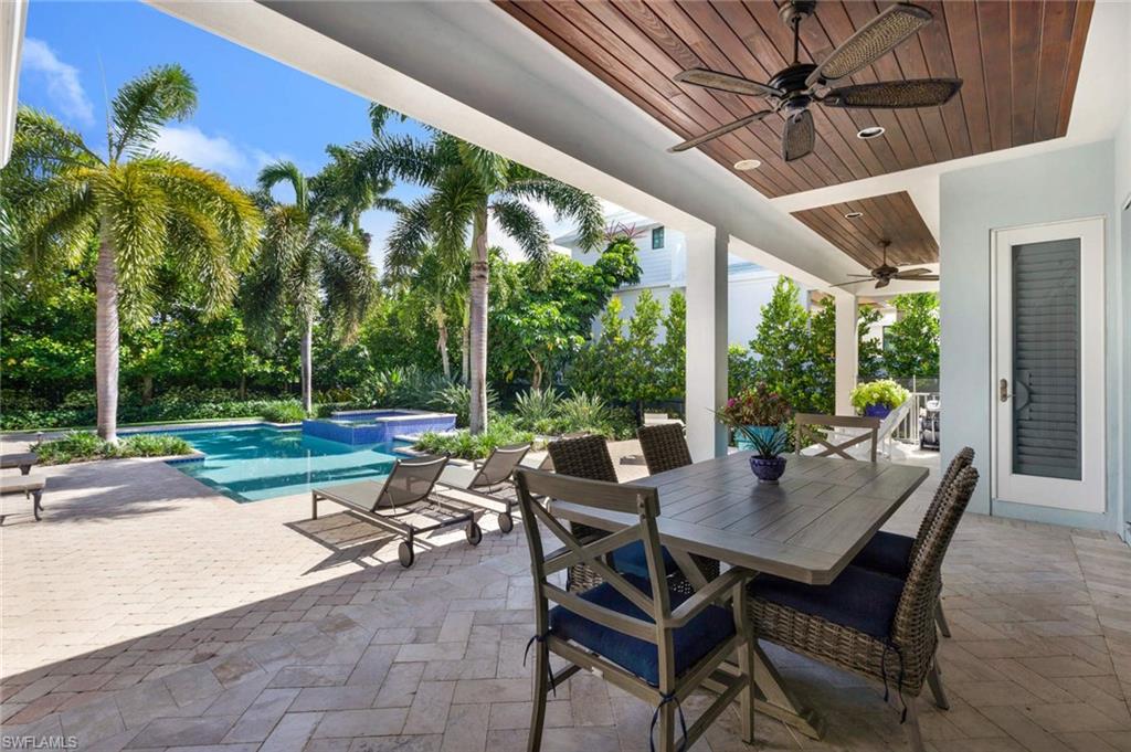 150 Central Avenue Naples, FL 34102 - Photo 21 of 35 a view of a patio with a table chairs and a backyard