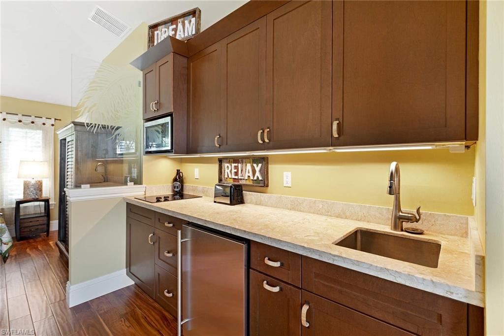 150 Central Avenue Naples, FL 34102 - Photo 28 of 35 a kitchen with a sink cabinets and wooden floor