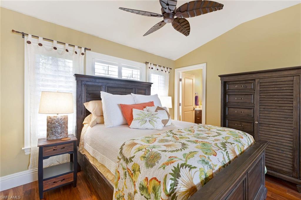 150 Central Avenue Naples, FL 34102 - Photo 29 of 35 a bedroom with a bed and a chandelier