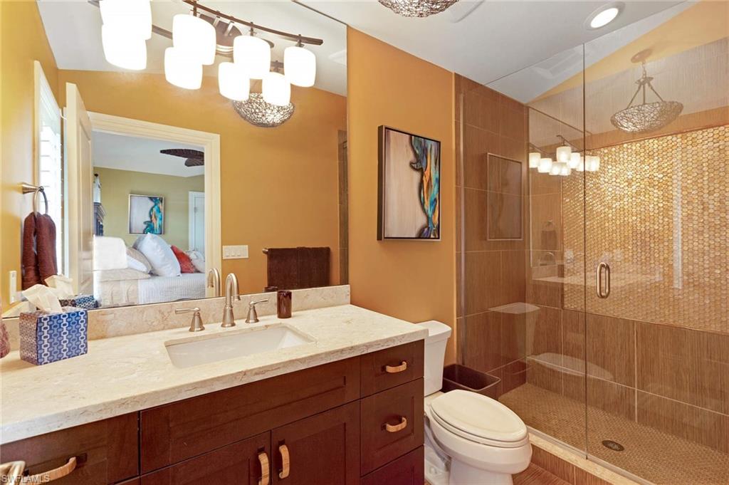 150 Central Avenue Naples, FL 34102 - Photo 30 of 35 a bathroom with a sink a toilet a mirror a vanity and shower
