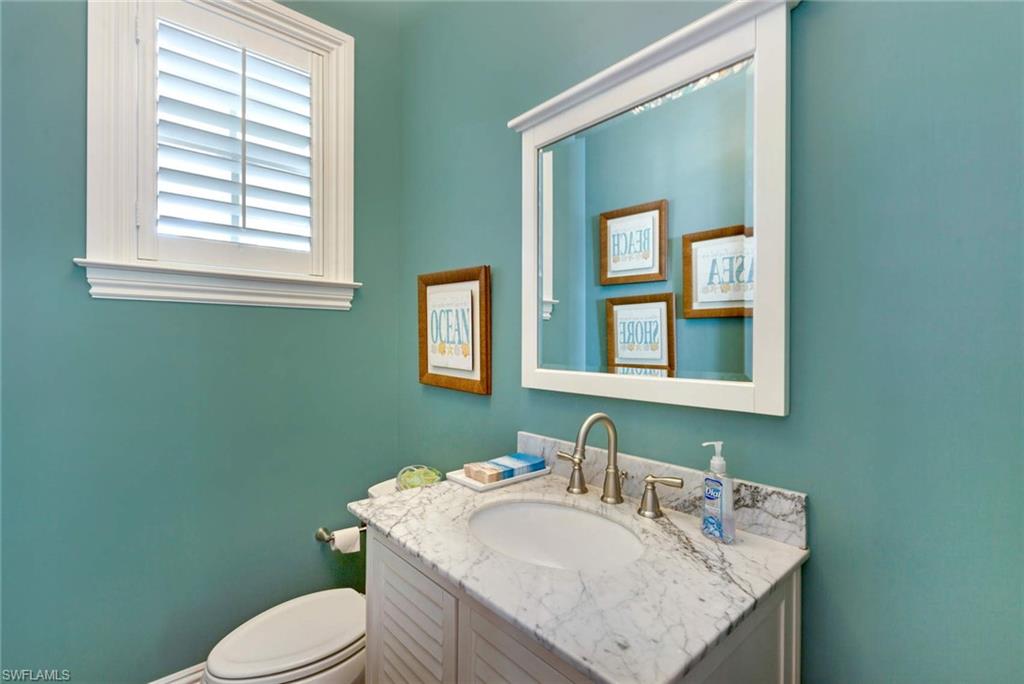 150 Central Avenue Naples, FL 34102 - Photo 8 of 35 a bathroom with a sink toilet and mirror
