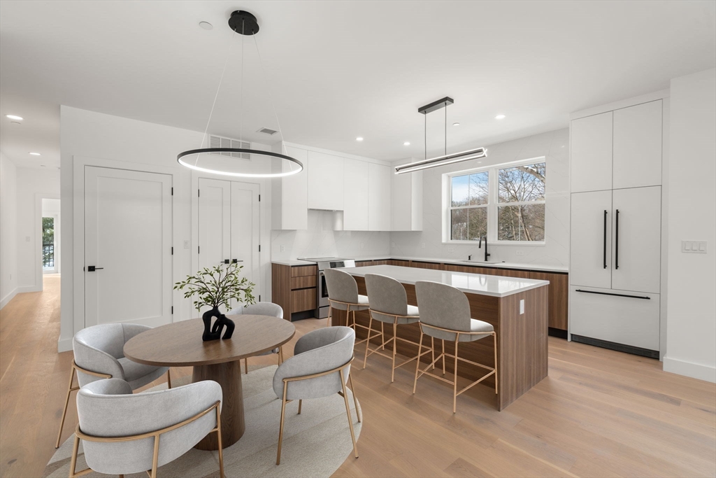 16 Stearns Road, Unit 106 Wellesley, MA 02482 - Photo 3 of 12 a dining room with furniture a window and chandelier