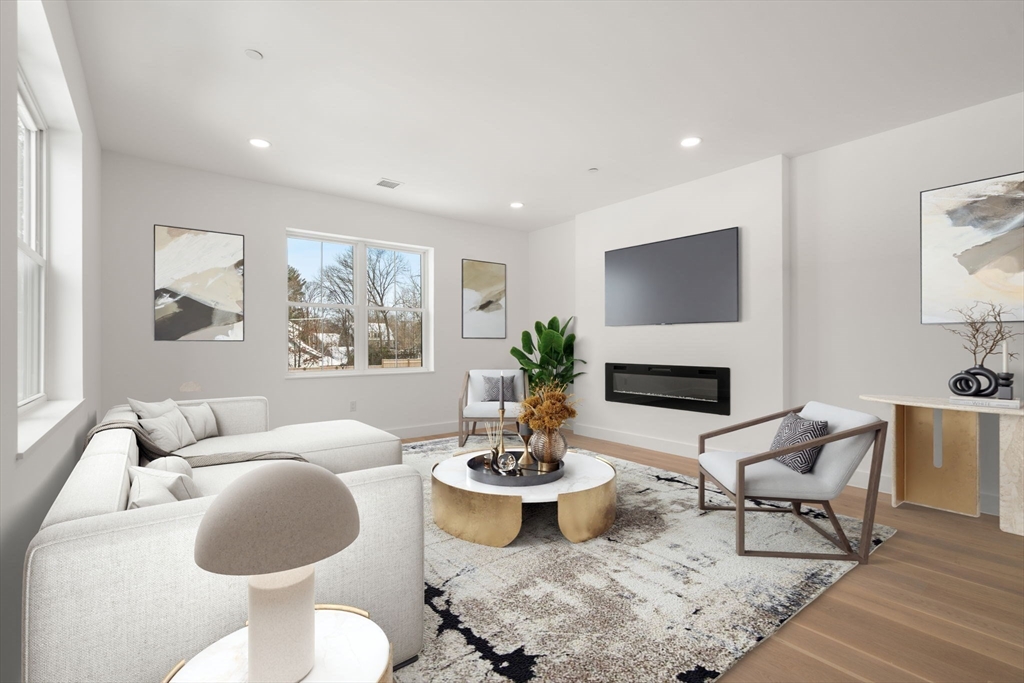 16 Stearns Road, Unit 106 Wellesley, MA 02482 - Photo 4 of 12 a living room with furniture a fireplace and a table