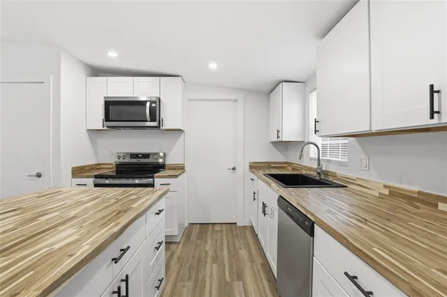 a kitchen with sink stove microwave and cabinets