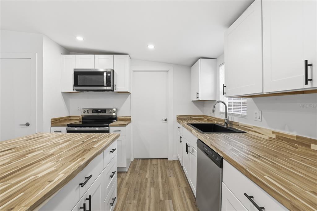 9024 Southwest 104th Terrace Gainesville, FL 32608 - Photo 13 of 21 a kitchen with sink stove microwave and cabinets