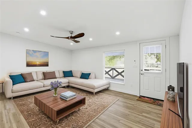 a living room with furniture and a wooden floor