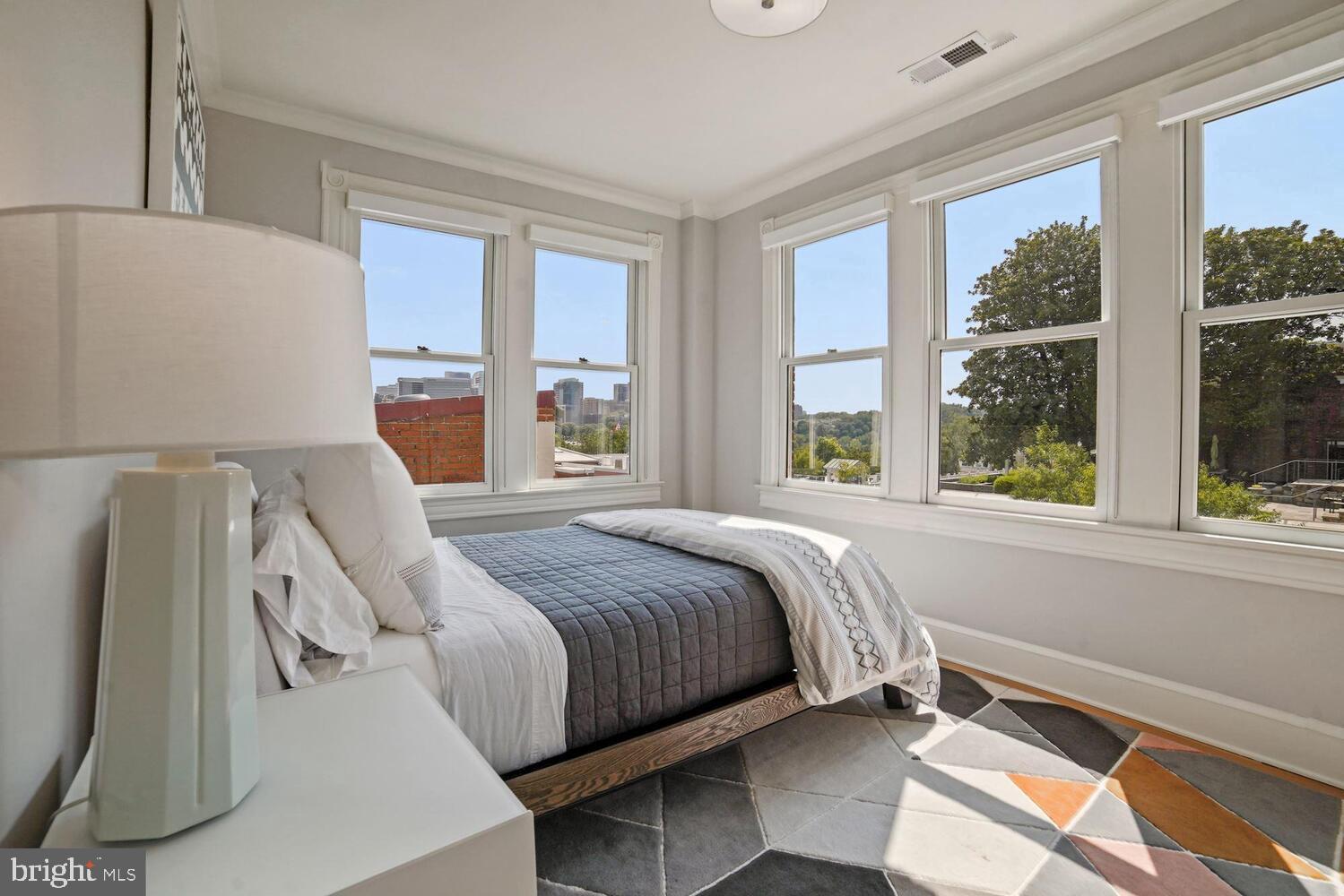 a bedroom with a bed and a large window