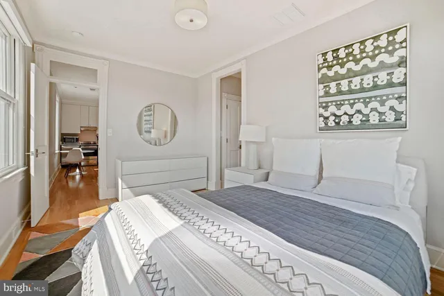 a bedroom with a bed a mirror and a table in it