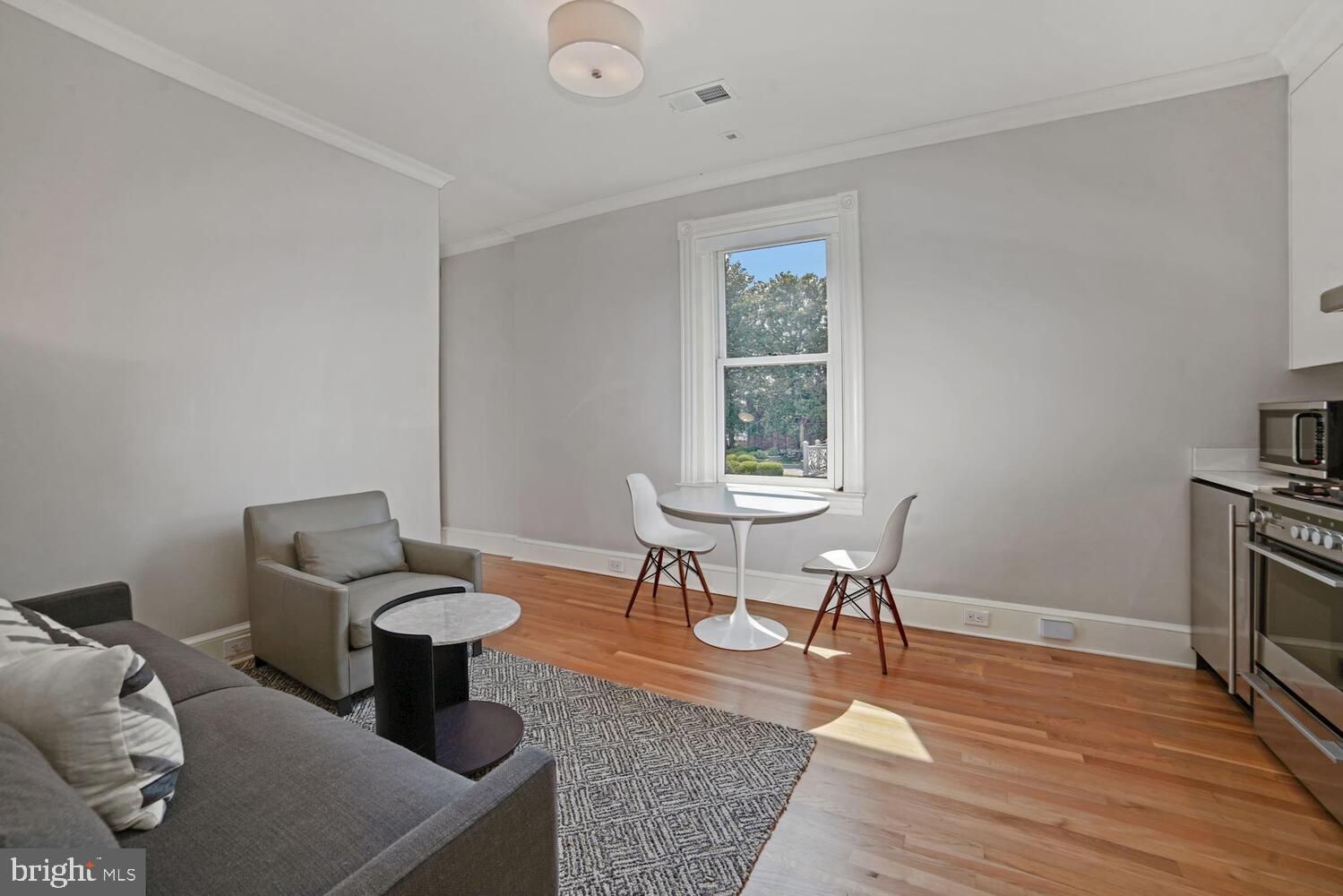 3348 Prospect Street Northwest, Unit 4 Washington, DC 20007 - Photo 5 of 12 a living room with furniture a flat screen tv and a table