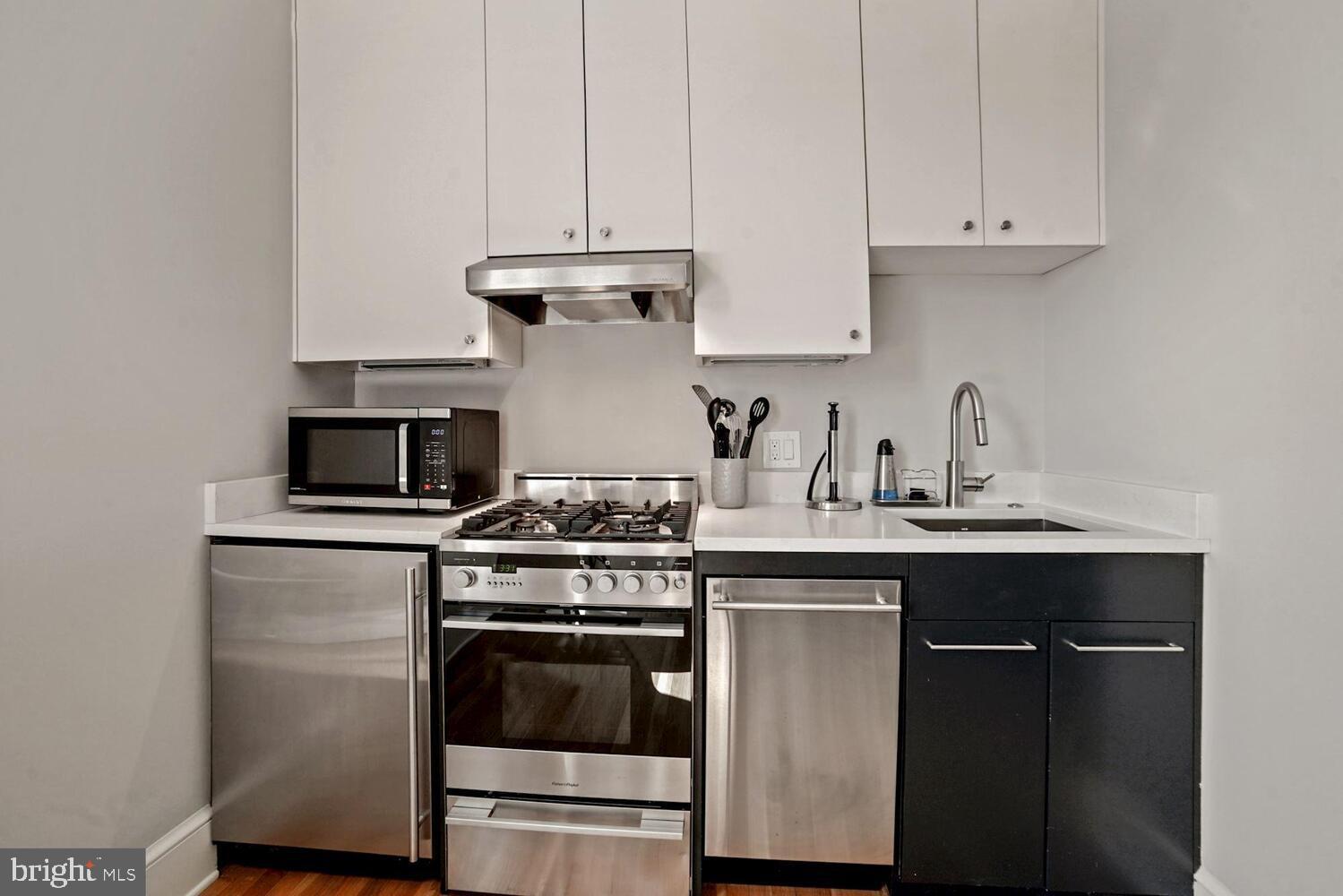 3348 Prospect Street Northwest, Unit 4 Washington, DC 20007 - Photo 7 of 12 a kitchen with cabinets stainless steel appliances and a sink