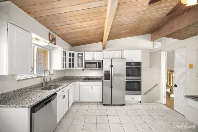 a kitchen with stainless steel appliances granite countertop a sink window and refrigerator