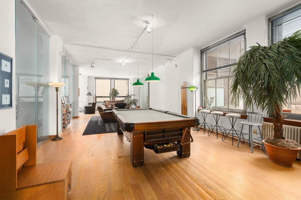 50 Pine Street, Unit 10 Manhattan, NY 10005 - Photo 7 of 14 a living room with furniture and a large window