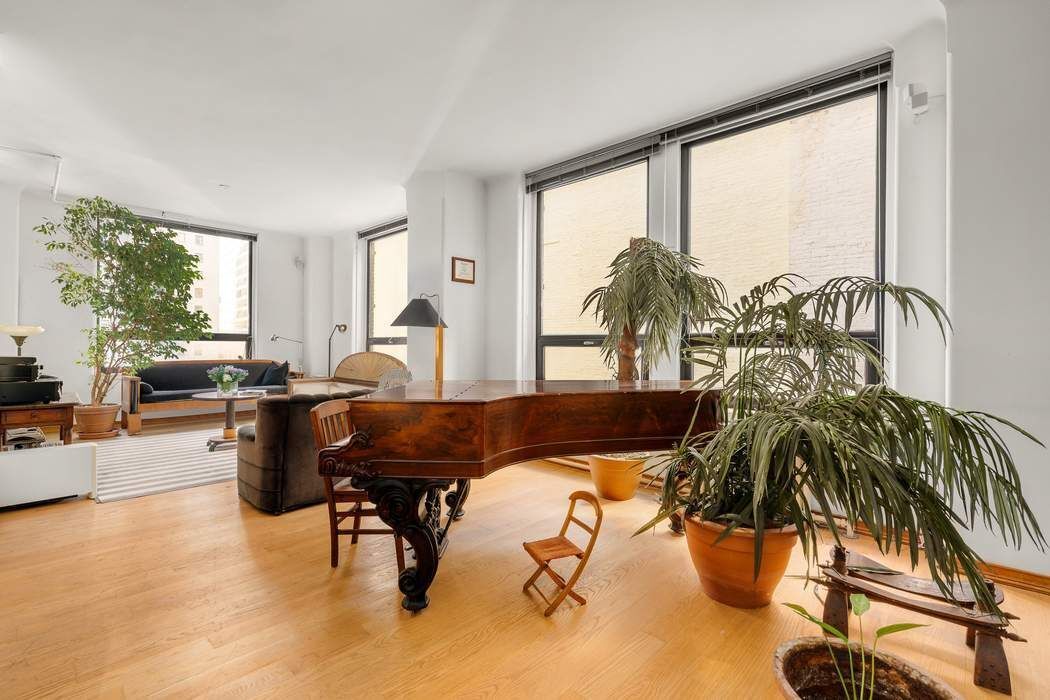50 Pine Street, Unit 10 Manhattan, NY 10005 - Photo 9 of 14 a living room filled with furniture and a floor to ceiling window