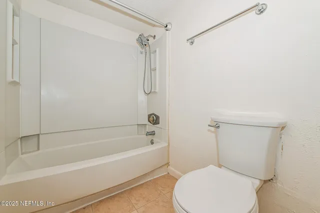 a white toilet sitting next to a bath tub
