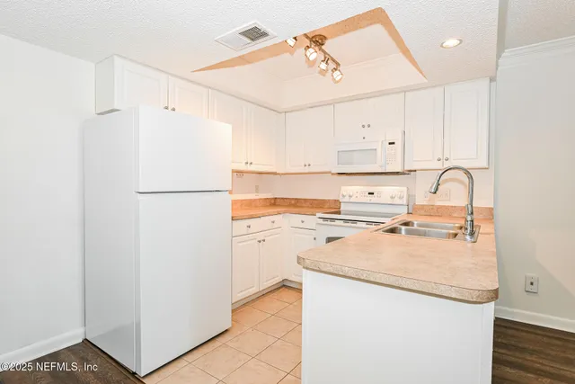 a kitchen with refrigerator cabinets and a sink