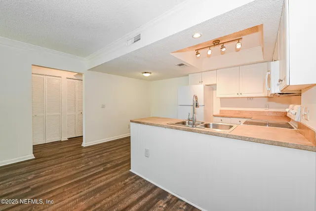 a view of a kitchen with a sink and wooden floor