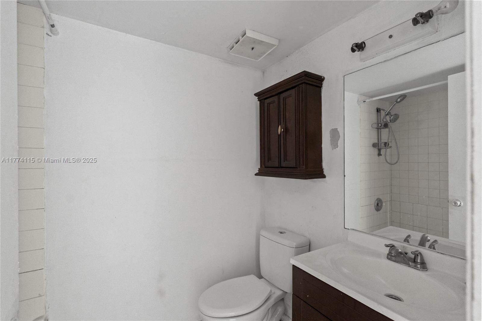 3199 Foxcroft Road, Unit 311 Miramar, FL 33025 - Photo 8 of 17 a bathroom with a toilet sink vanity and mirror