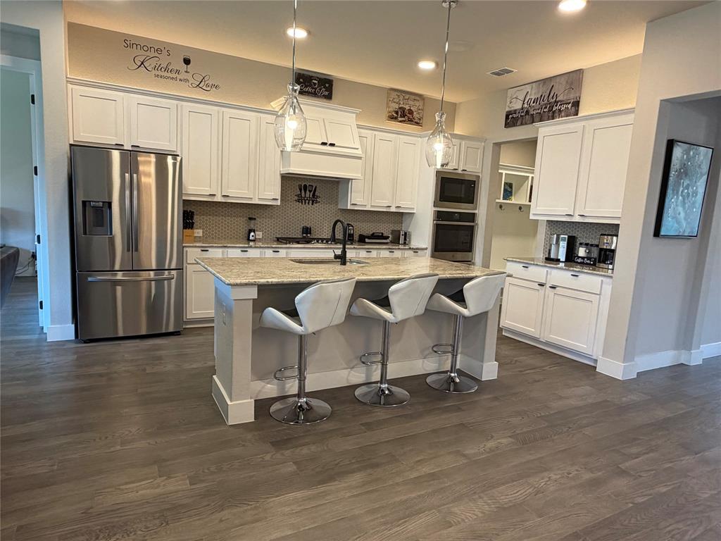 862 Mildren Lane Fate, TX 75087 - Photo 13 of 40 a kitchen with stainless steel appliances a refrigerator a stove a sink and white cabinets