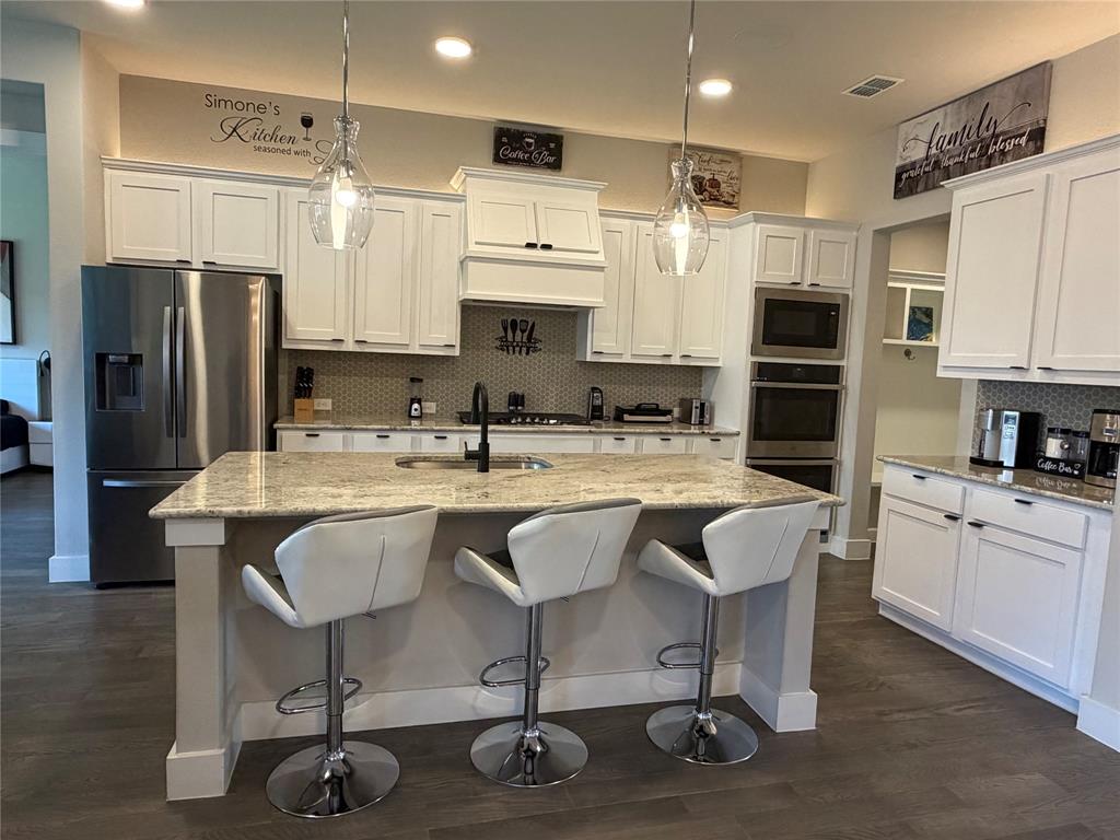 862 Mildren Lane Fate, TX 75087 - Photo 14 of 40 a kitchen with stainless steel appliances granite countertop a sink refrigerator and cabinets
