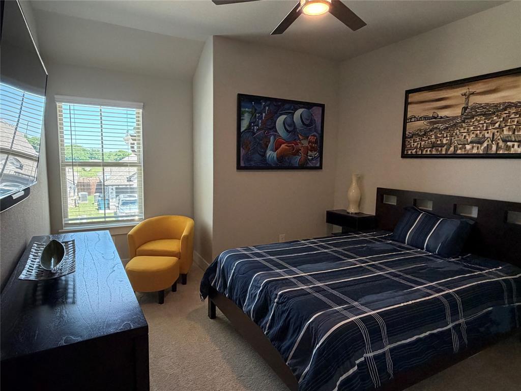862 Mildren Lane Fate, TX 75087 - Photo 25 of 40 a bedroom with a bed and a couch next to a window
