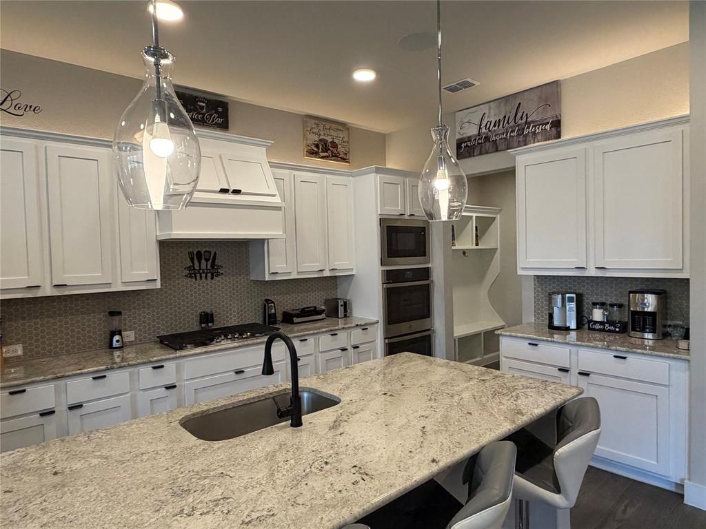 862 Mildren Lane Fate, TX 75087 - Photo 9 of 40 a kitchen with stainless steel appliances kitchen island granite countertop a sink refrigerator and cabinets