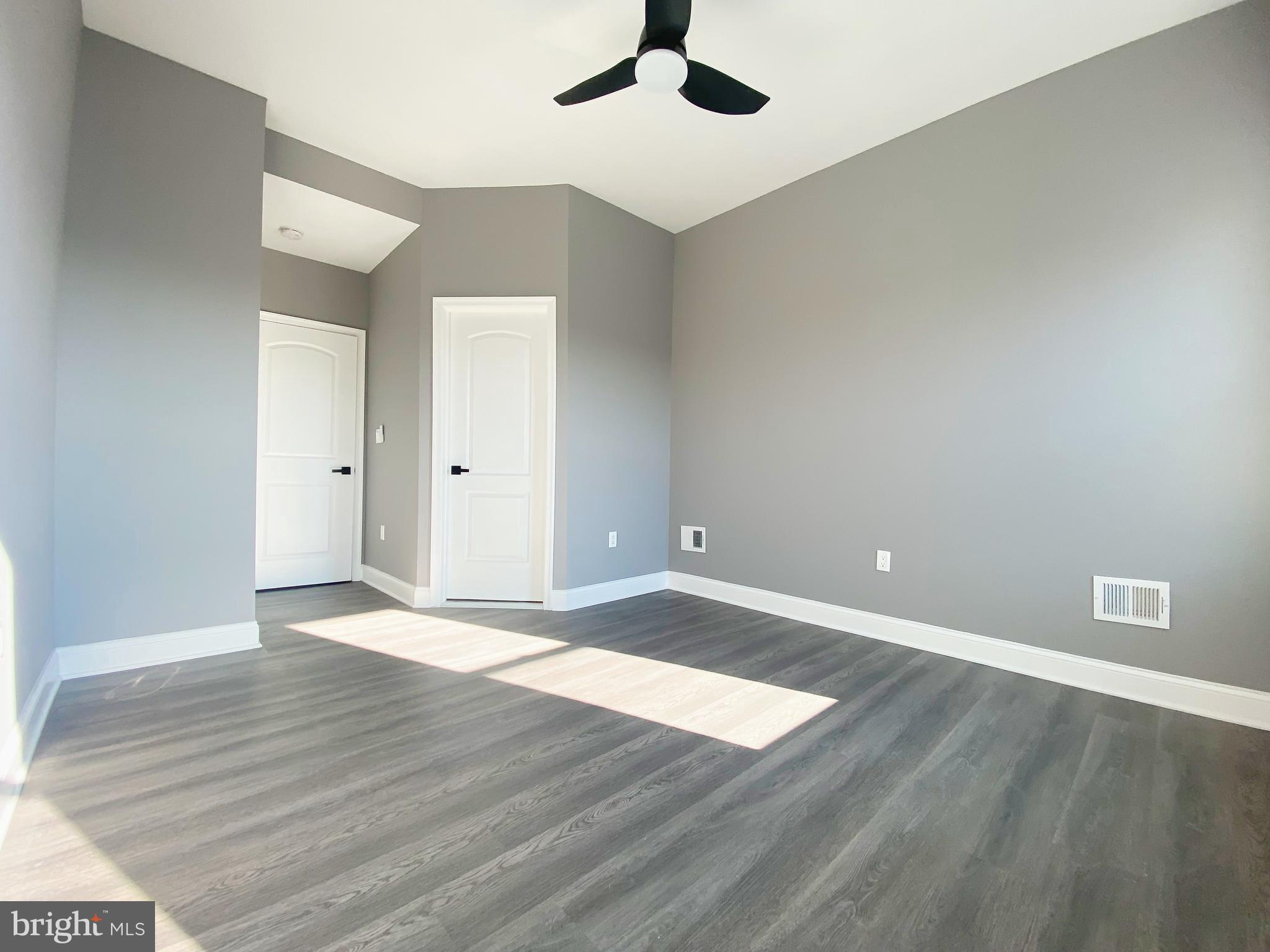 1604 Cliftview Avenue Baltimore, MD 21213 - Photo 15 of 34 an empty room with wooden floor and windows