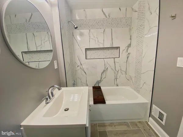 a bathroom with a sink a mirror and a shower