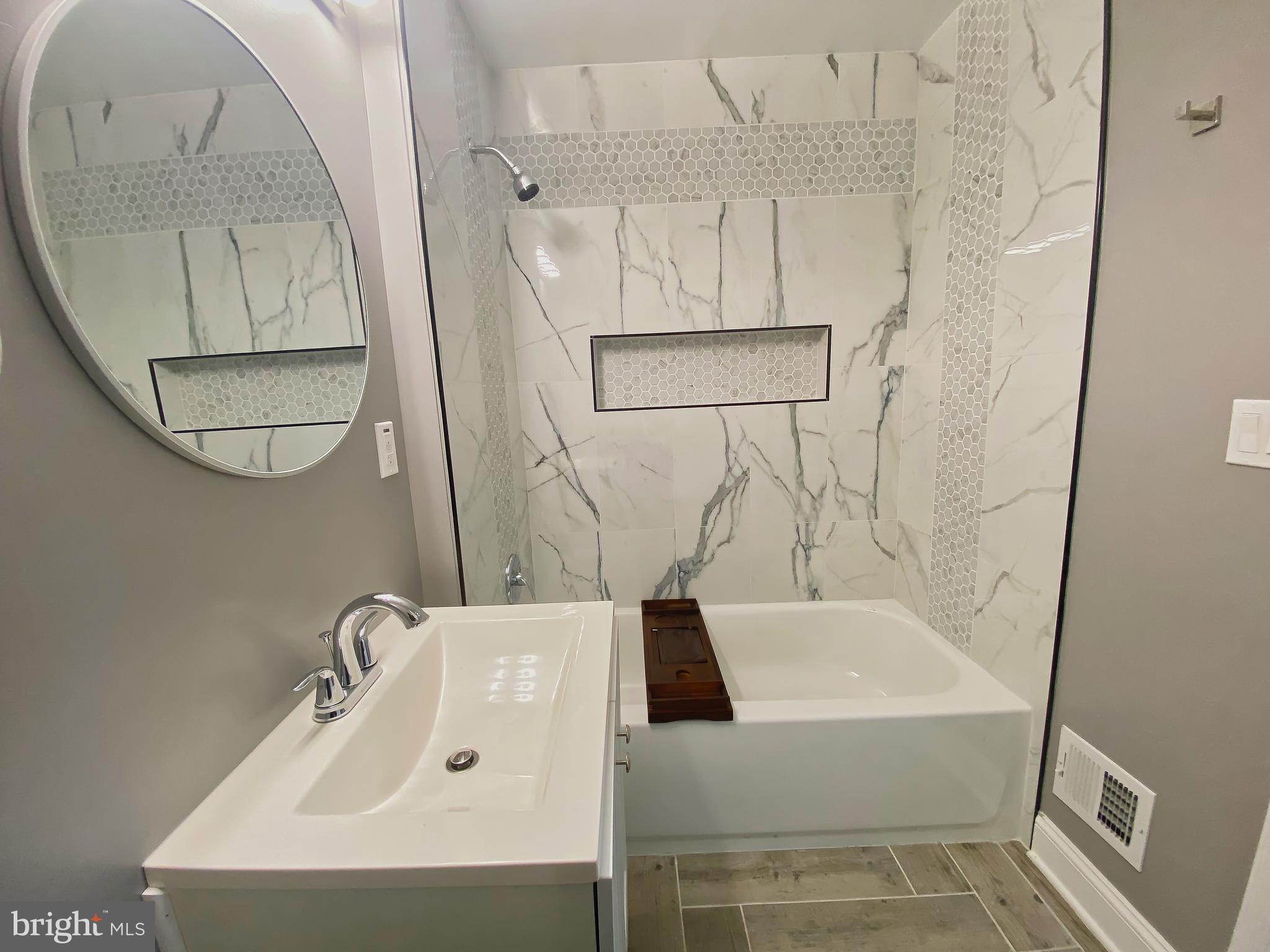1604 Cliftview Avenue Baltimore, MD 21213 - Photo 20 of 34 a bathroom with a sink a mirror and a shower