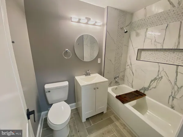 a bathroom with a sink a toilet and a mirror