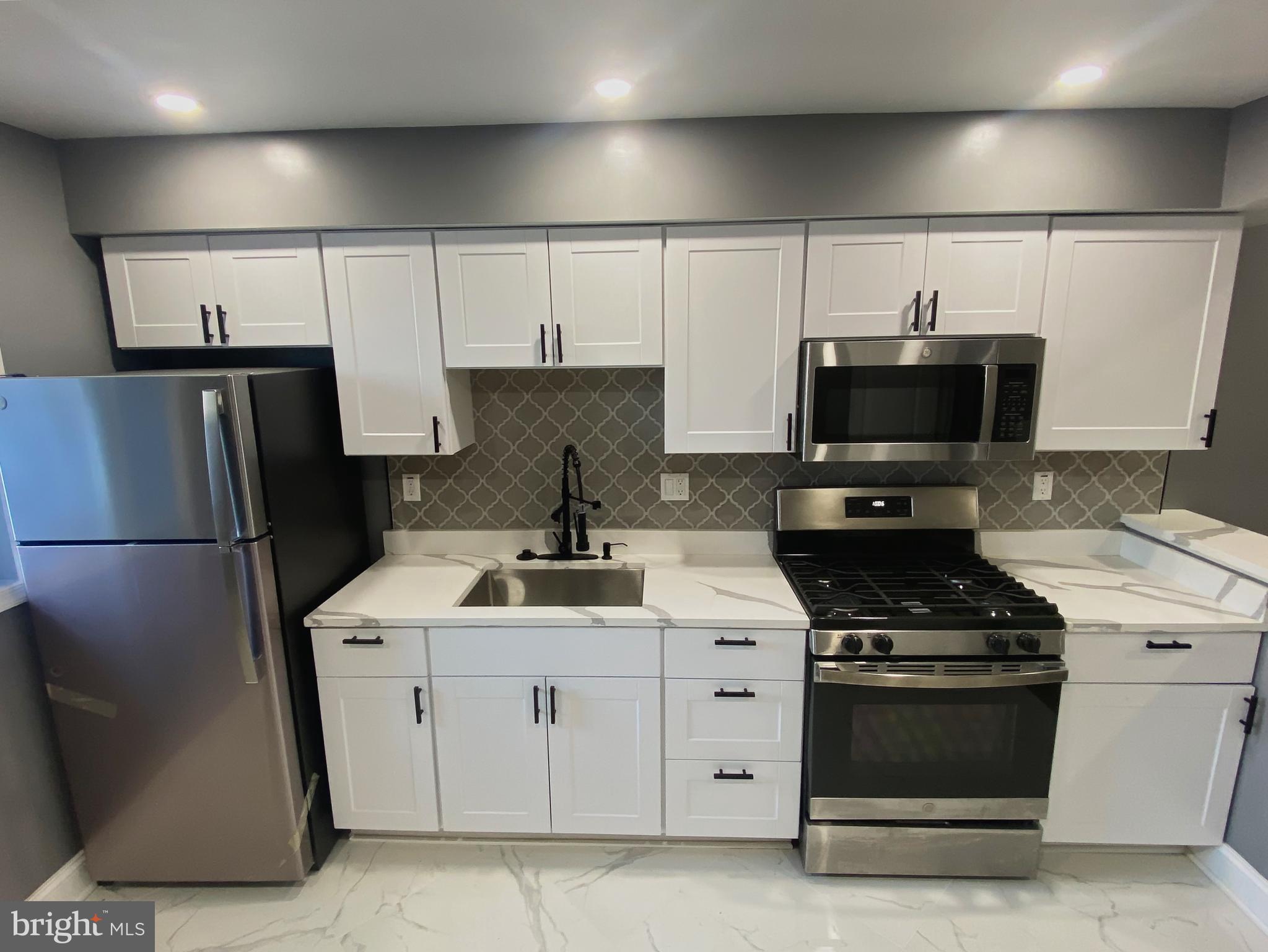 1604 Cliftview Avenue Baltimore, MD 21213 - Photo 5 of 34 a kitchen with stainless steel appliances a refrigerator a stove a sink and a refrigerator