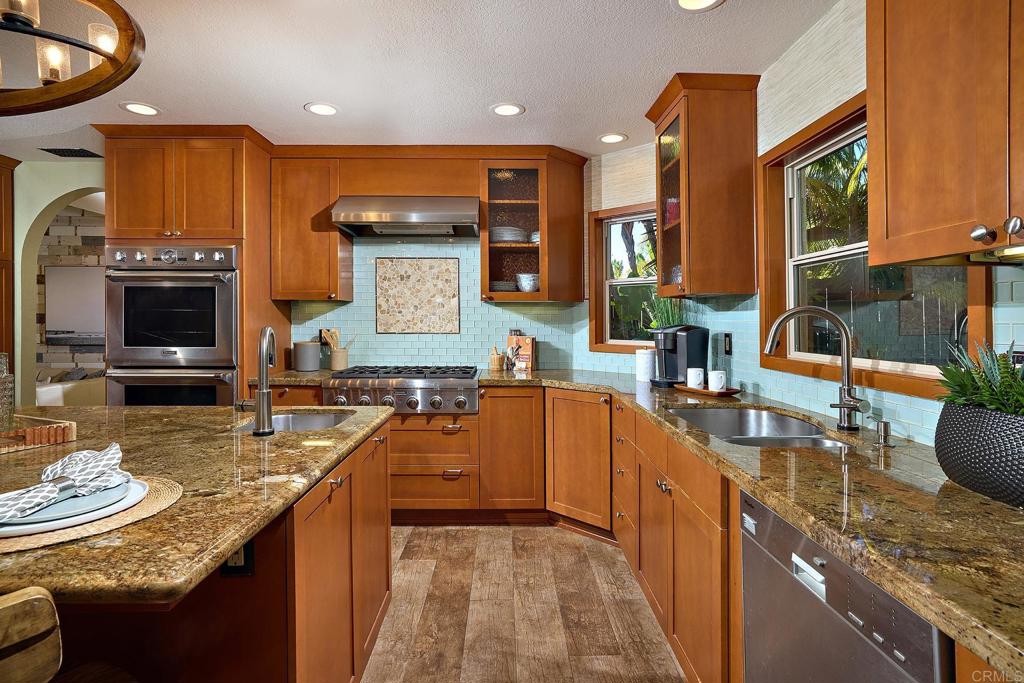 1323 Calle Scott Encinitas, CA 92024 - Photo 9 of 28 a kitchen with stainless steel appliances granite countertop a sink a stove and a wooden cabinets