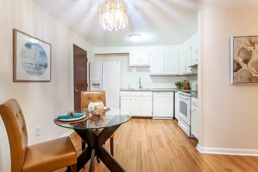 420 Great Road, Unit C2 Acton, MA 01720 - Photo 6 of 20 a kitchen with stainless steel appliances granite countertop a dining table chairs and white cabinets