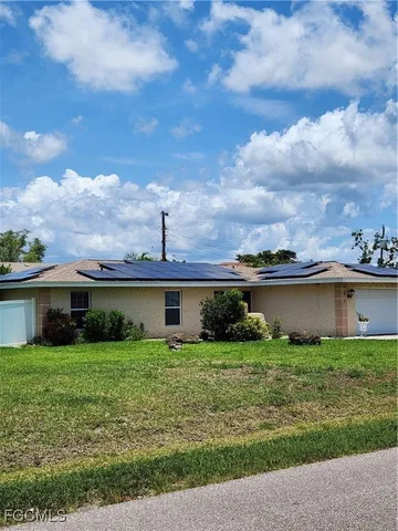 a view of a house with a yard and sitting area