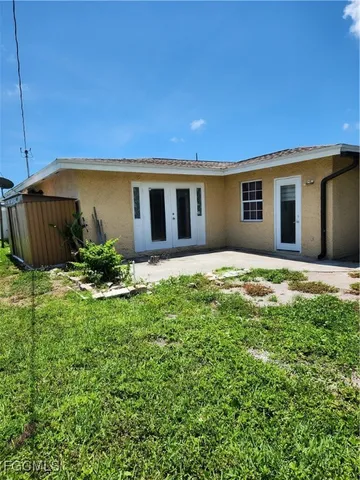 a front view of a house with a yard and trees