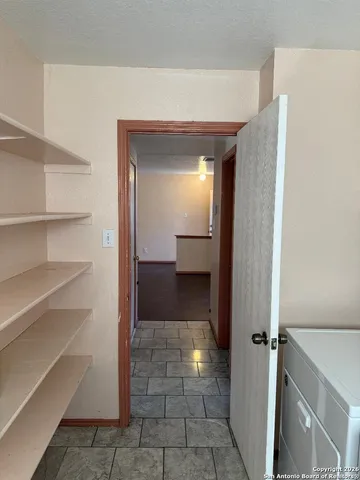 a view of a hallway with wooden shelves