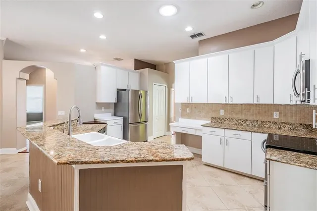 a large kitchen with stainless steel appliances kitchen island granite countertop a large counter top and granite top