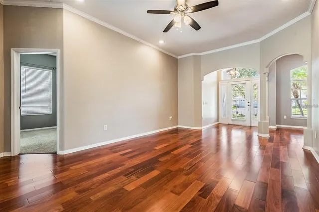 a view of an empty room with a window and wooden floor