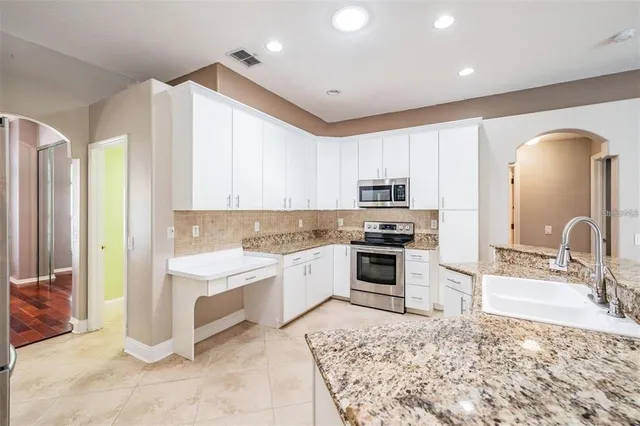 a kitchen with stainless steel appliances granite countertop a stove and a sink