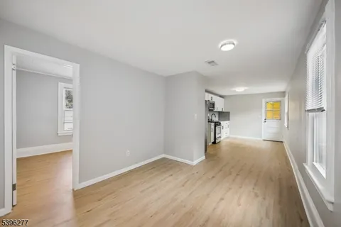 a view of a big room with wooden floor and windows