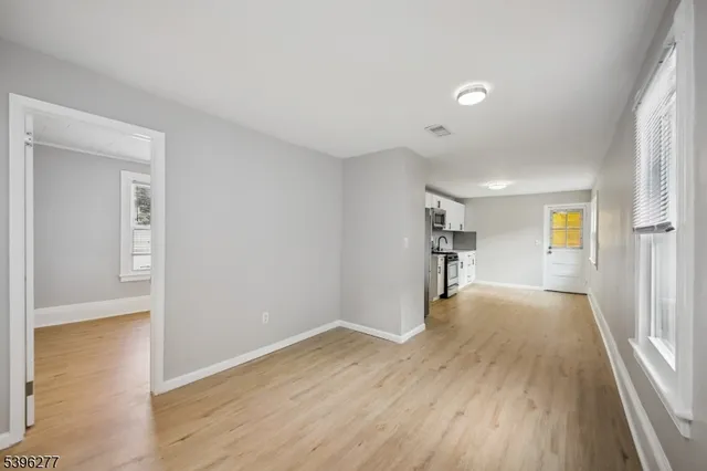 a view of a big room with wooden floor and windows
