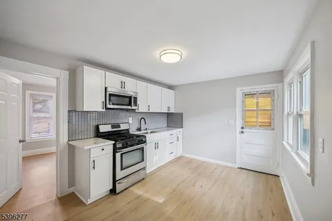 a kitchen with stainless steel appliances a stove top oven and a refrigerator