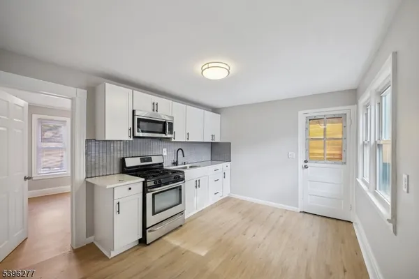 a kitchen with stainless steel appliances a stove top oven and a refrigerator