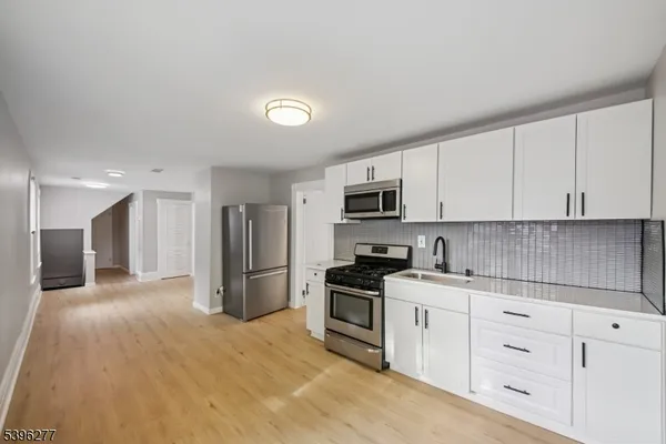 a kitchen with stainless steel appliances white cabinets and a refrigerator