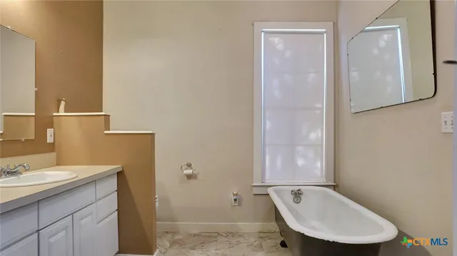 a bathroom with a granite countertop sink a toilet and mirror