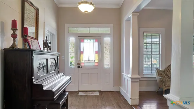 a view of a hallway with furniture and wooden floor