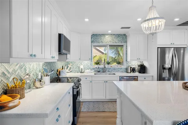 a kitchen with stainless steel appliances granite countertop a refrigerator a stove and a sink