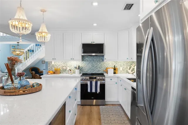 a kitchen with a stove a kitchen island a dining table and chairs