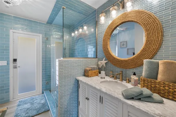 a bathroom with a toilet a sink a mirror and shower