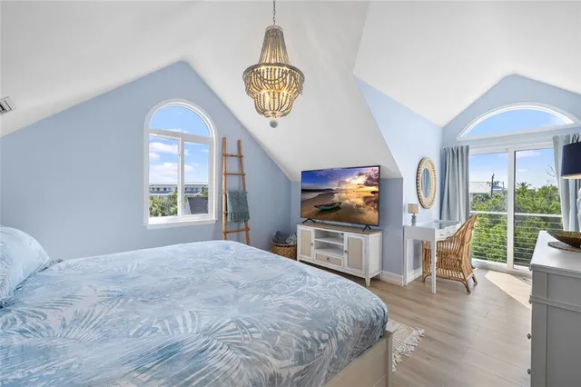 a bedroom with a bed and a chandelier